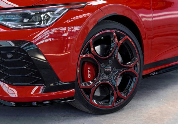 Imagen de la parte delantera del nuevo GOLF GTI 50 de color rojo, con visión especial a la llanta.