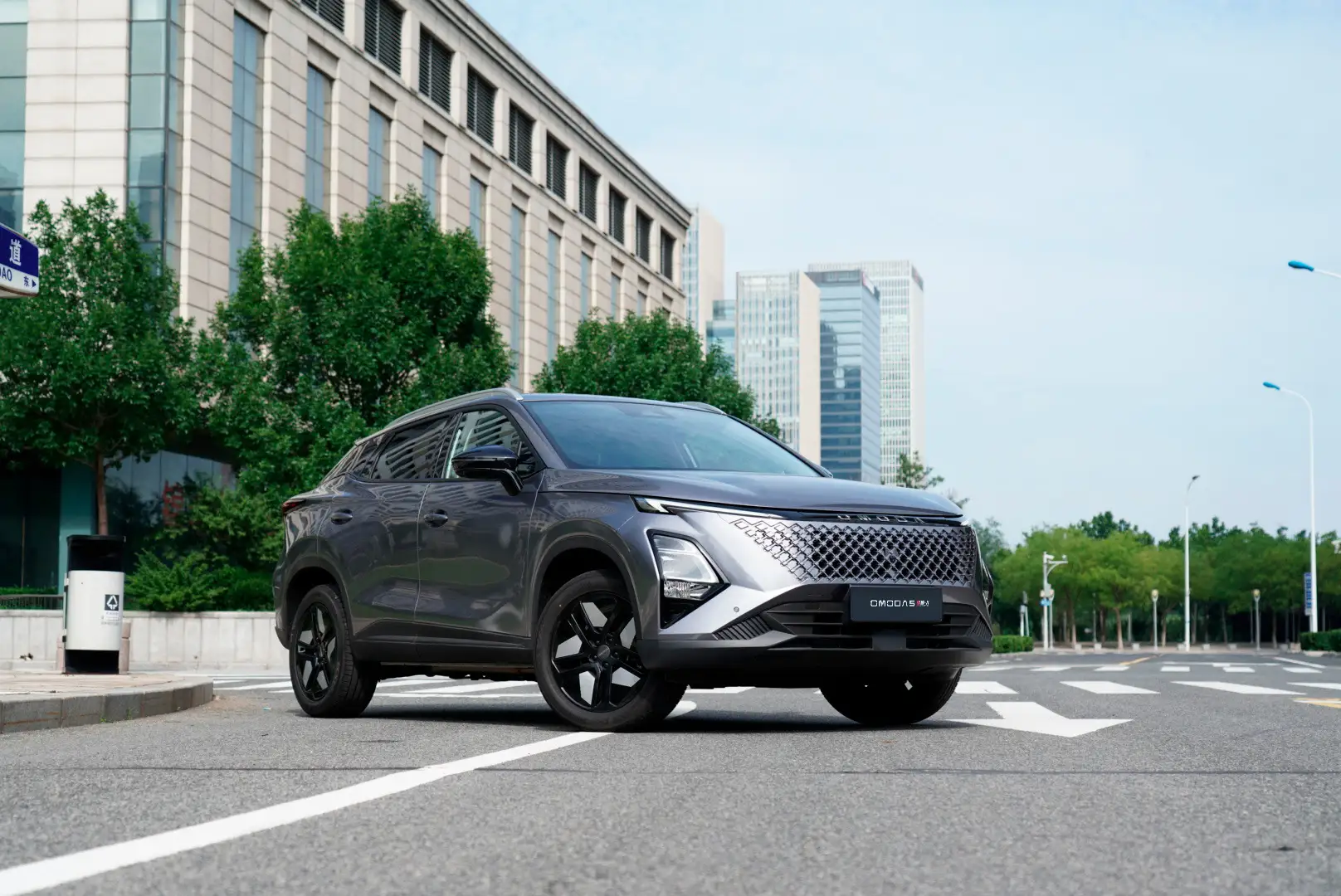 imagen del nuevo omoda 5 hibrido sobre el asfalto de una calle en un día soleado