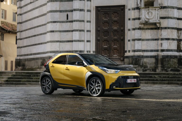 Imagen del nuevo Toyota Aygo X Híbrido de color amarillo y techo negro en una calle de día