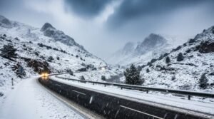 Imagen de una carretera entre montañas cubiertas de nieve por la Borrasca Francis