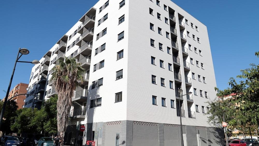 València extiende a los 45 años la protección para acceder a una vivienda de alquiler asequible Edificio moderno con vegetación cercana en Safranar-Valencia.