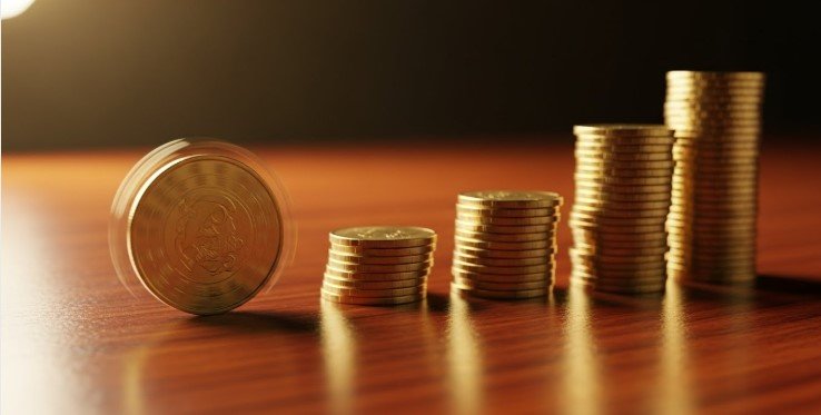 Imagen que muestra varios montones de monedas, desde menos monedas hasta más simulando el crecimiento de un ahorro con interés compuesto.