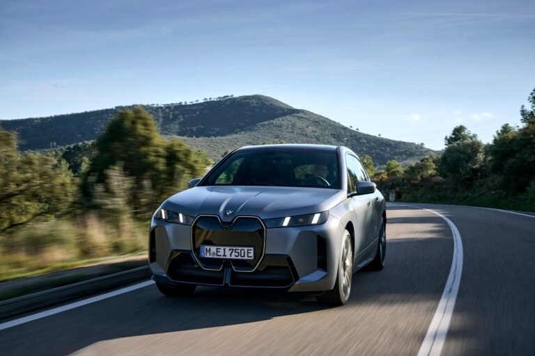 Imagen de un bmw circulando por carrera en un día soleado.