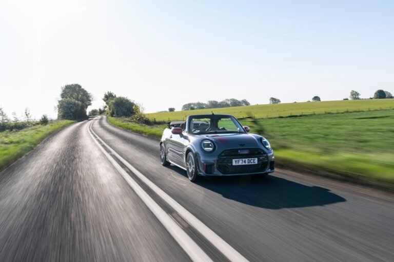 Imagen de un mini por una carretera soleada