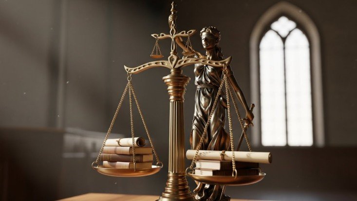 Imagen que muestra una balanza de la justicia con documentos en ambos lados de la balanza