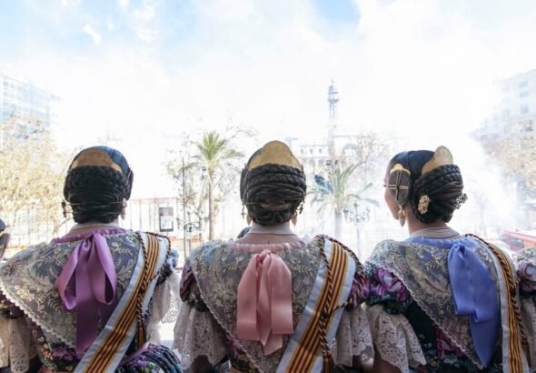 Falleras disfrutando de una Mascletá desde el balcón del Ayuntamiento.