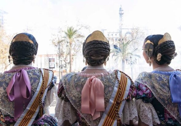 Falleras viendo la mascletá desde el balcón del Ayuntamiento de Valencia.