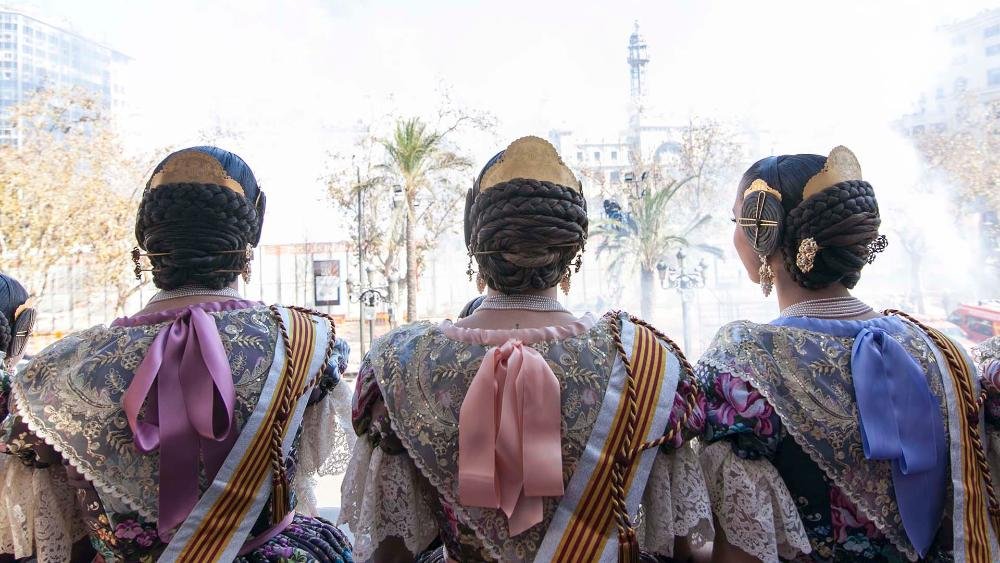 Falleras viendo la mascletá desde el balcón del Ayuntamiento de Valencia.