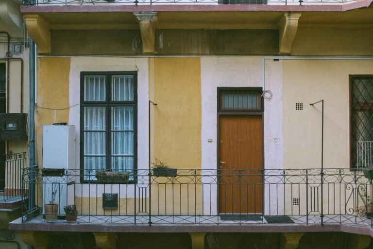 Imagen de la entrada de una vivienda en una finca de color amarillo.