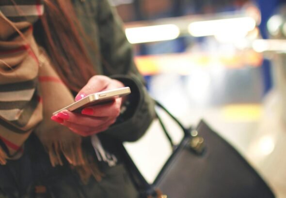 La imagen muestra una persona con un móvil en la mano mirando la pantalla de su móvil leyendo la noticia sobre violencia-sexual-digital