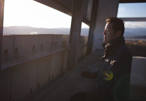 Persona mirando el paisaje al atardecer años más tarde del accidente nuclear de Fukushima.