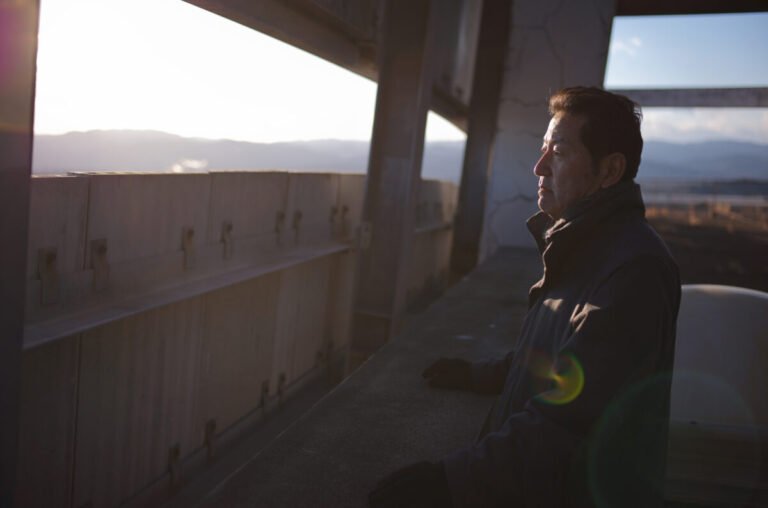 Persona mirando el paisaje al atardecer años más tarde del accidente nuclear de Fukushima.