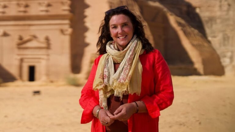 Mujer en desierto con monumentos antiguos.