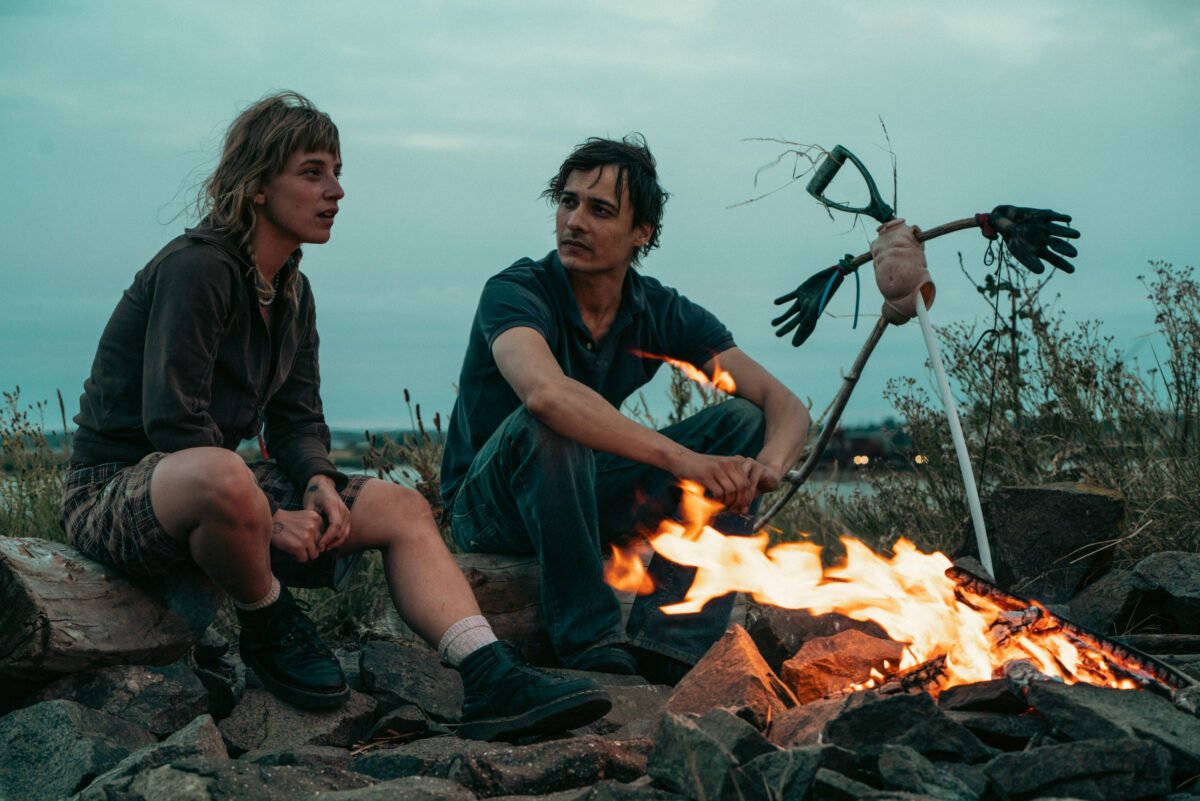 Filmin estrena el 6 de marzo la película "Urchin" dirigida por Harris Dickinson Dos personas junto a una fogata.
