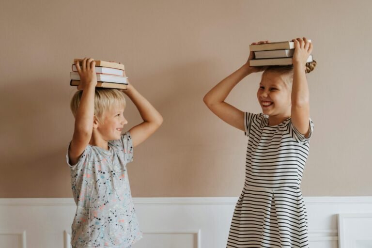 Niños sosteniendo libros sobre la cabeza.