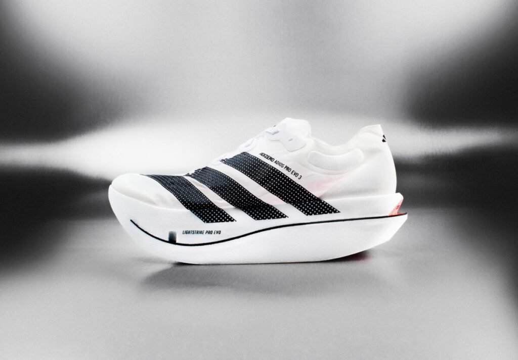 ¿Pagarías 500 € por volar? Así es la nueva joya de adidas que pesa menos que un móvil Imagen parte lateral de las nuevas adidas Adizero Evo 2026 de color blanco con 3 líneas negras.