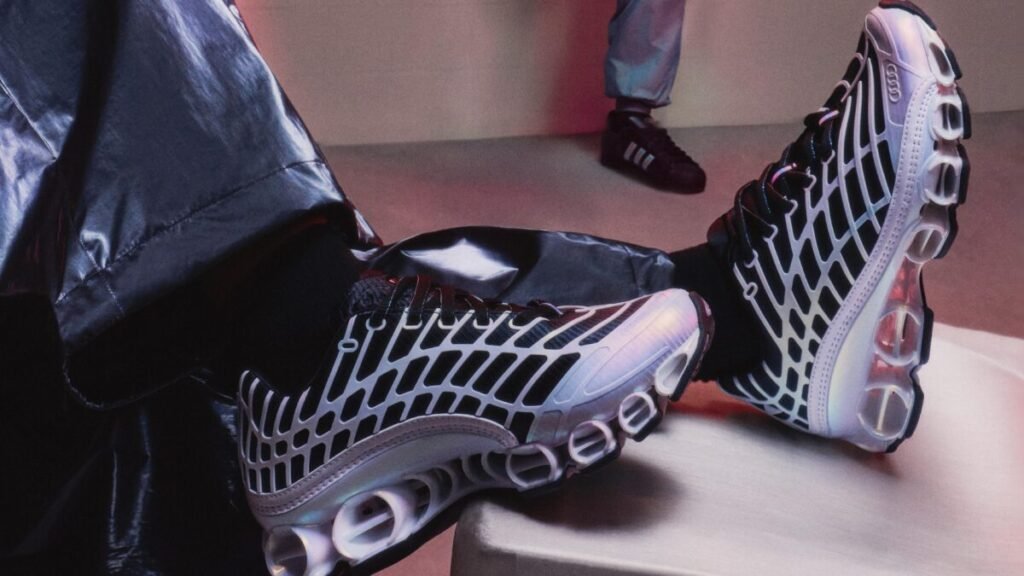 La estética del fútbol de 2006 salta a la Fórmula 1 con la nueva colección de adidas y Audi Vista de las zapatillas Megaride F50 con paneles de diseño de telaraña sobre una base de malla negra de la nueva colección de adidas y Audi Revolut F1