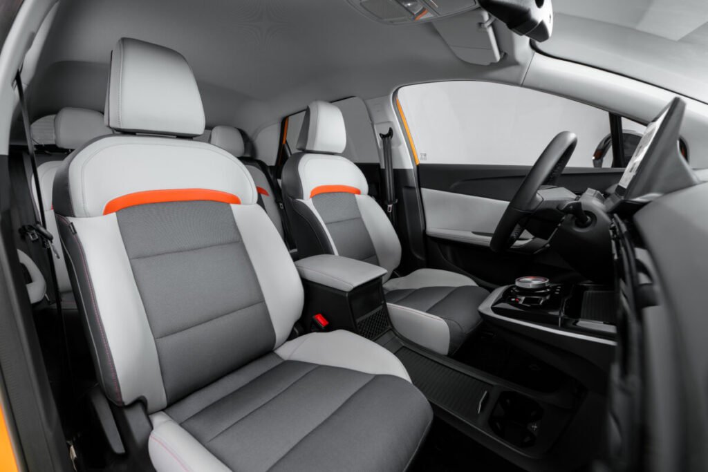 MG4 EV 2026: El coche que puso en jaque a las marcas europeas Interior del MG4 EV con sillones gris y detalles naranja.