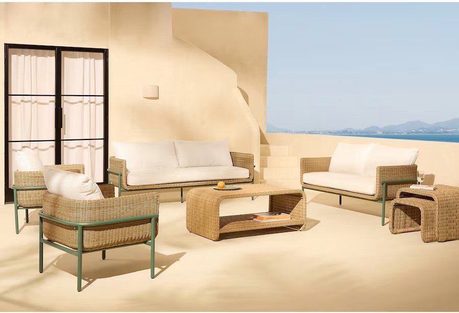 Terraza de jardín con patas de aluminio y asientos en fibra sintética trenzada.