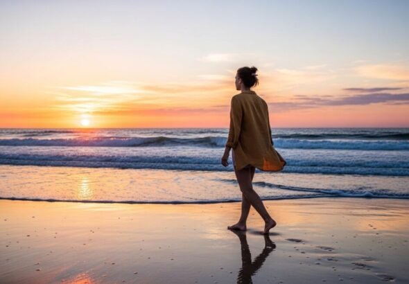 chica paseando por la playa con una chaqueta de color mostaza cuello mao y cirre de alamares