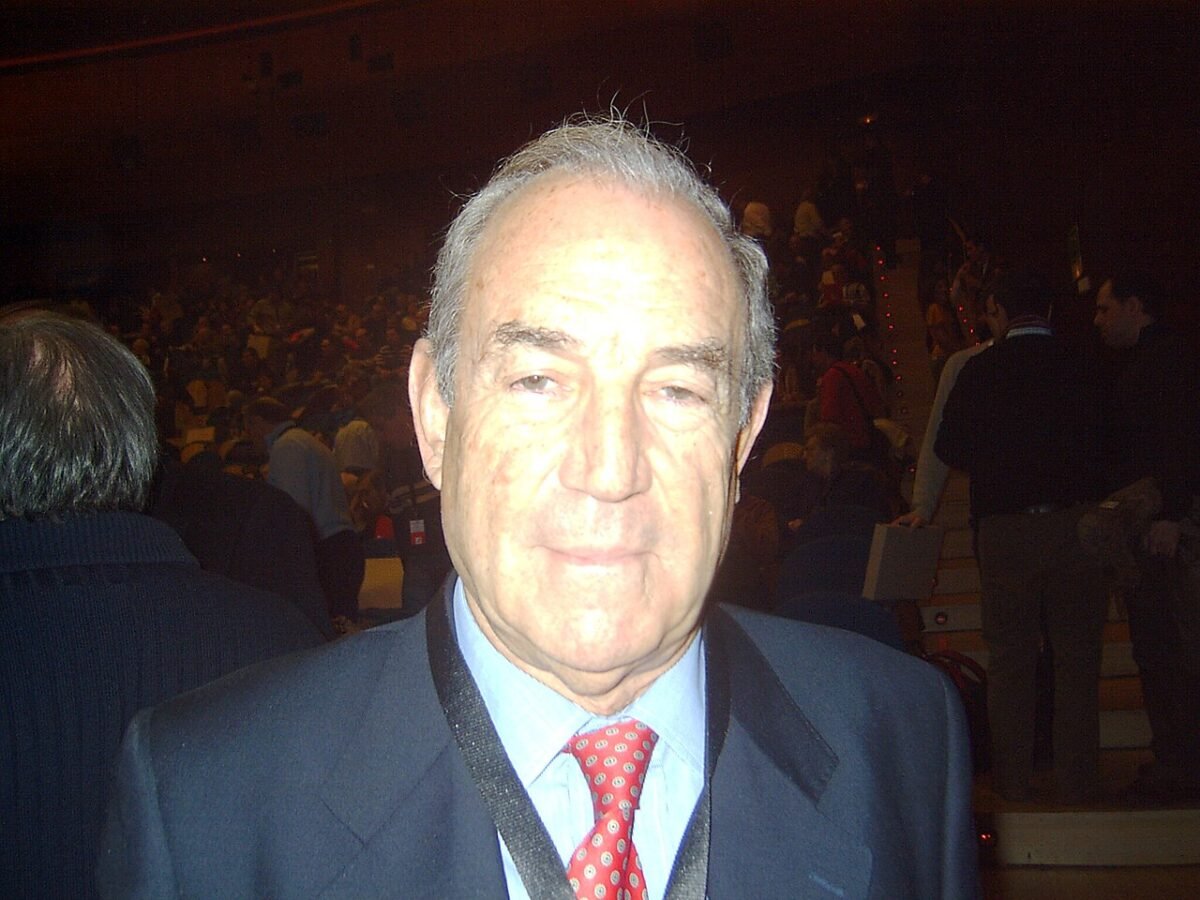 Retrato de Carlos Garaikoetxea, primer lehendakari de la democracia, durante un acto institucional, vistiendo traje y corbata sobre un fondo neutro.