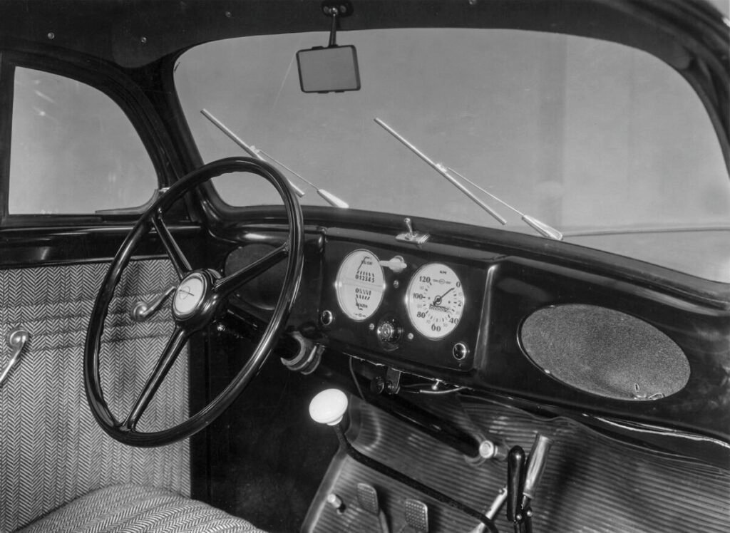 El coche que puso a rodar a un país: La legendaria saga del Opel Kadett Imagen del interior que muestra el salpicadero con volante y asiento del conductos del Opel Kadett 1936-1938