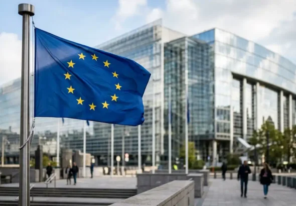 Imagen que muestra la bandera de la Unión Europea con un edificio moderno de cristal que ilustra la nueva norma contra las deepfakes sexuales.