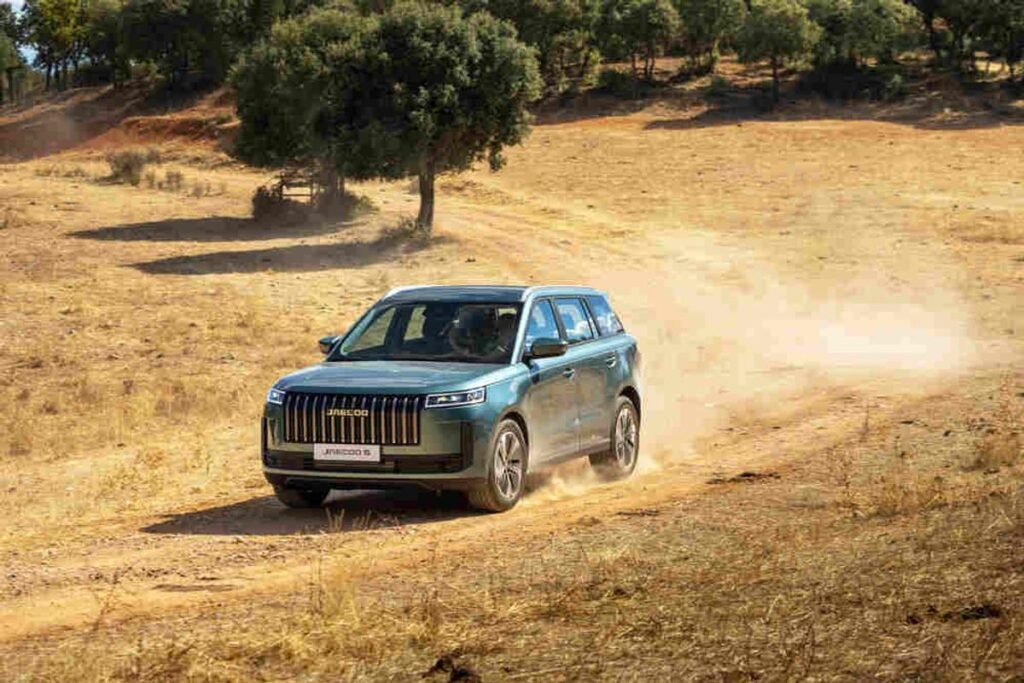 ¿Es este el SUV más inteligente de su clase? El motivo de su éxito Imagen del coche JAECOO 5 por un camino de tierra en montaña. Vista del exterior.