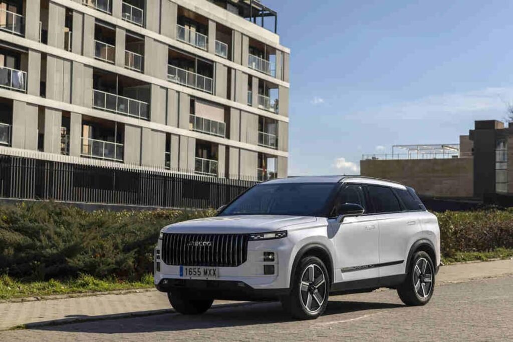 Tiene 340 CV, etiqueta CERO y un interior de lujo por mucho menos de lo que imaginas Imagen exterior del JAECOO 7 de color blanco aparcado en una calle, con vista frontal y lateral.