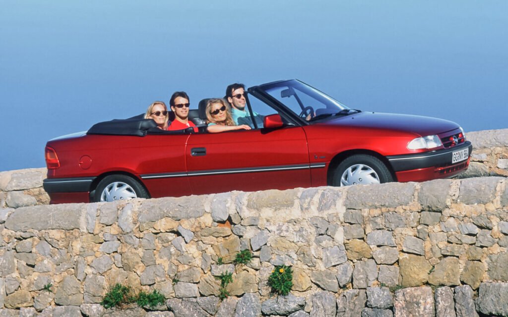 Del éxito de los 90 al rayo eléctrico: El viaje épico del Opel Astra Imagen del Opel Astra 1991 cabrio de color rojo circulando