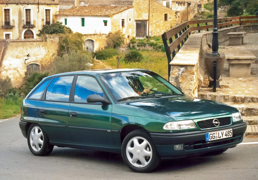 Del éxito de los 90 al rayo eléctrico: El viaje épico del Opel Astra Opel Astra 1991 vista exterior en color verde frontal y lateral