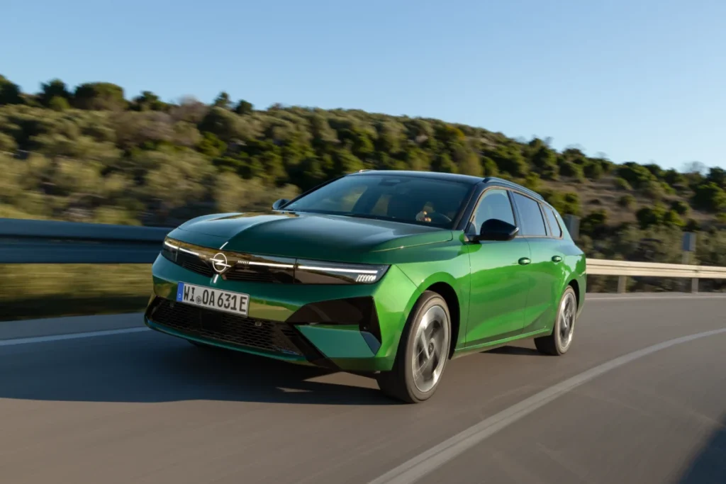 ¿El compacto definitivo? El nuevo Opel Astra se ilumina y baja de precio Imagen del nuevo Opel Astra de color verde circulando por carretera.