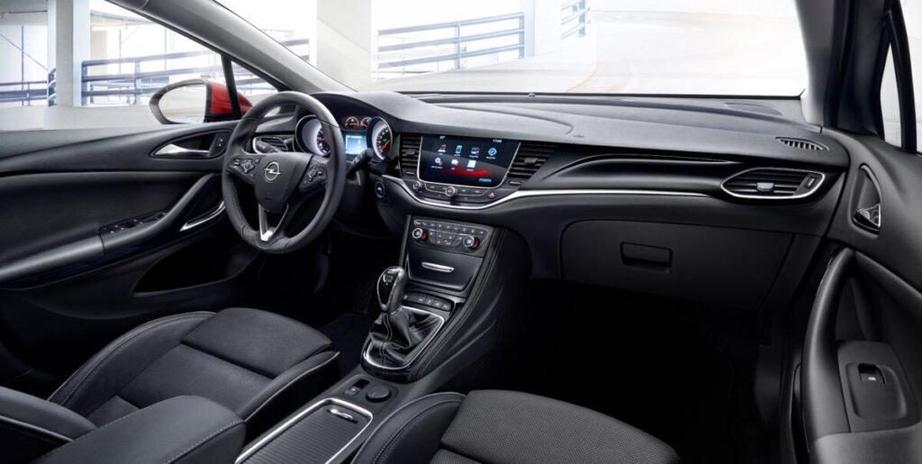 Del éxito de los 90 al rayo eléctrico: El viaje épico del Opel Astra Imagen del interior del Opel Astra K de 2015 que muestra el salpicadero y los asientos delanteros de conductos y copiloto