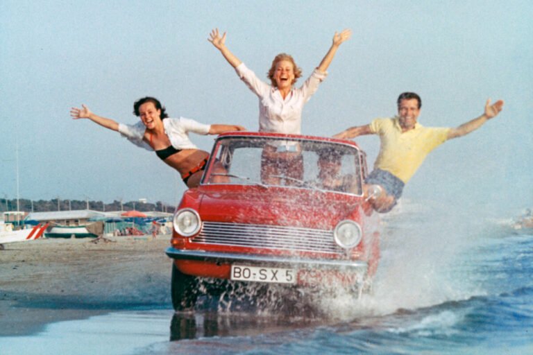 El coche que puso a rodar a un país: La legendaria saga del Opel Kadett Imagen del Opel Kadett A 1962 exterior circulando por la orilla de la playa
