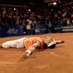 Imagen que muestra a Rafa Nadal en una pista de tierra batida tirado en el suelo con la raqueta a un lado