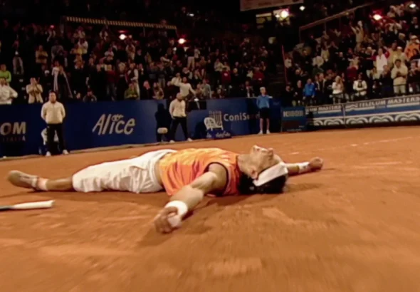 Imagen que muestra a Rafa Nadal en una pista de tierra batida tirado en el suelo con la raqueta a un lado
