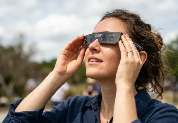 Imagen que muestra a una persona observando un eclipse con las gafas de protección para la salud ocular