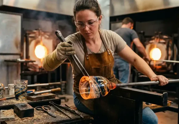 Una persona está trabajando con vidrio caliente para hacer un vaso, sobre el nuevo convenio de vidrio y cerámica