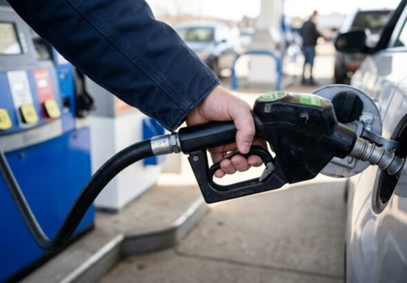 Imagen que muestra una persona con el surtidor de la gasolinera Moeve llenando el depósito de su coche