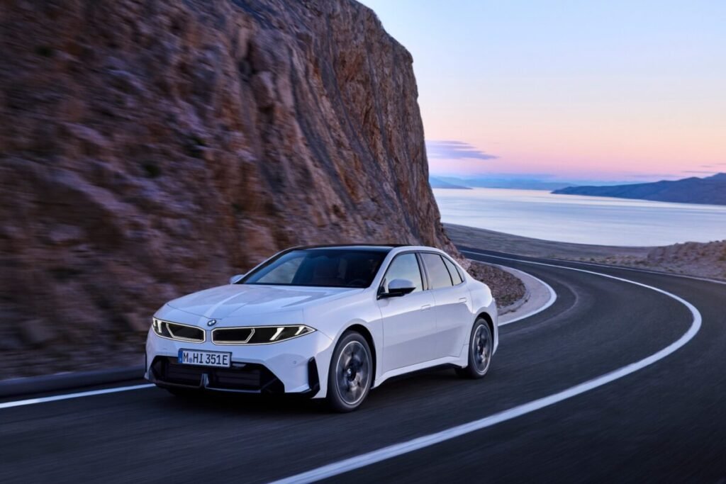 Así es el nuevo BMW i3 50 xDrive: la berlina eléctrica de los 906 km de autonomía que ya puedes reservar Imagen que muestra el exterior del nuevo BMW i3 circulando por una curva en carretera, de color blanco.