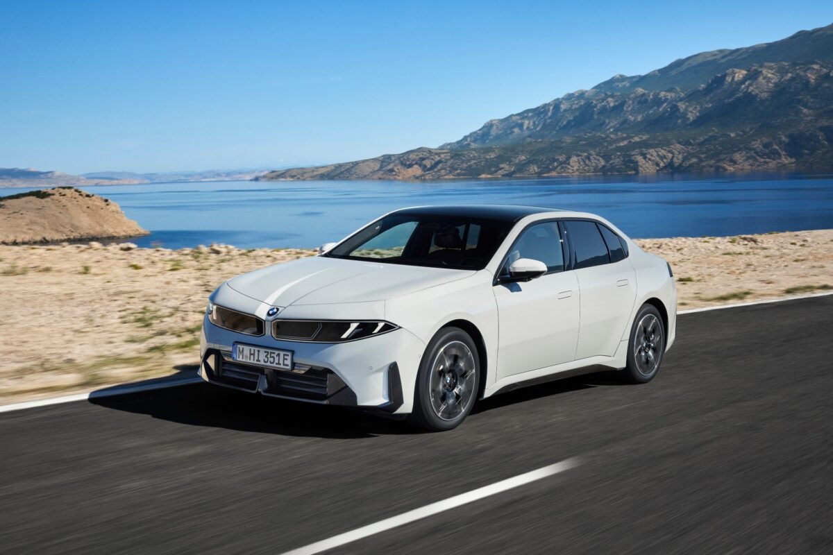 Imagen que muestra el nuevo BMW i3 . Exterior de color blanco, circulando por carretera con el mar de fondo