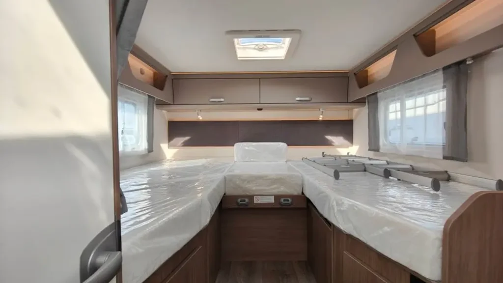 Ni hotel ni apartamento: la tendencia que arrasa para viajar por Andalucía este verano Imagen que muestra la parte de camas de la autocaravana Carado T447 vista horizontal