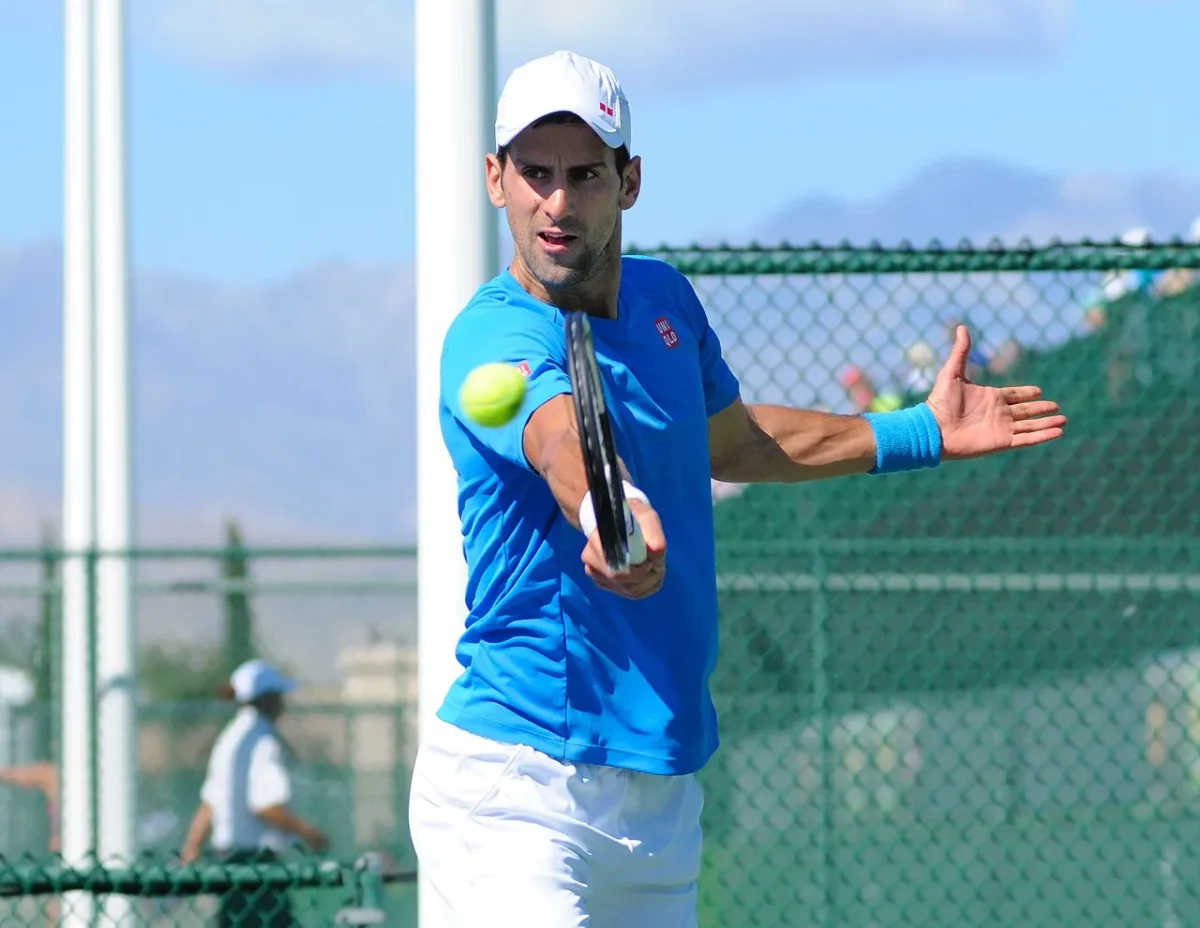 Imagen que muestra a Novak Djokovic en un campo con una raqueta golpeando la pelota