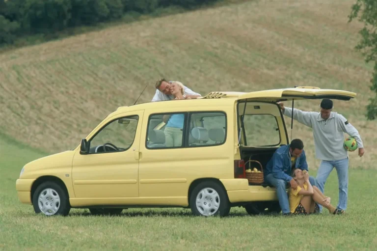 Imagen de la Citroën Berlingo de archivo, de color amarillo. Vista del exterior con el portón trasero abierto.