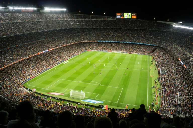 Imagen que muestra un campo de fútbol abarrotado de gente con los fútbolistas posicionados en una de las alineaciones del fútbol actual