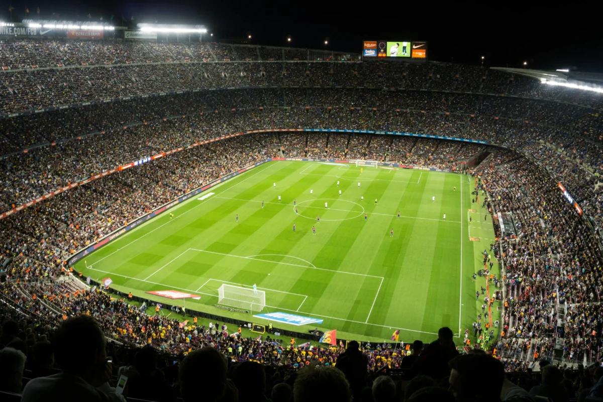 Imagen que muestra un campo de fútbol abarrotado de gente con los fútbolistas posicionados en una de las alineaciones del fútbol actual