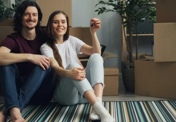 Imagen de una pareja que acaba de firmar su hipoteca y está en su salón con las cajas de mudanza