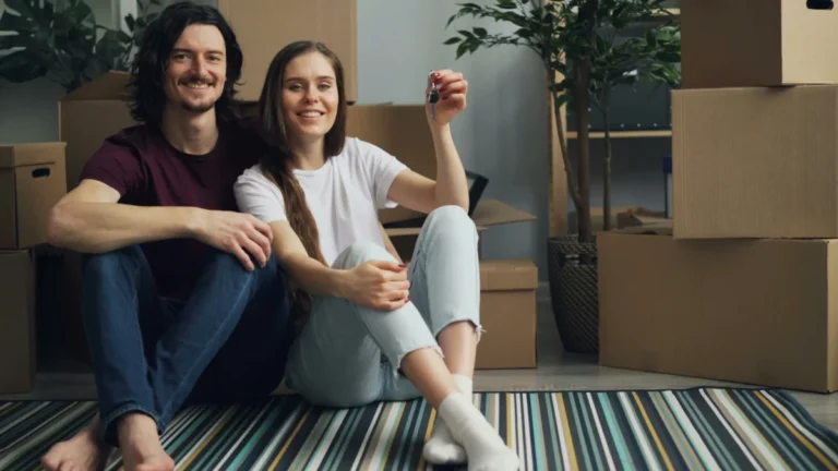 Imagen de una pareja que acaba de firmar su hipoteca y está en su salón con las cajas de mudanza