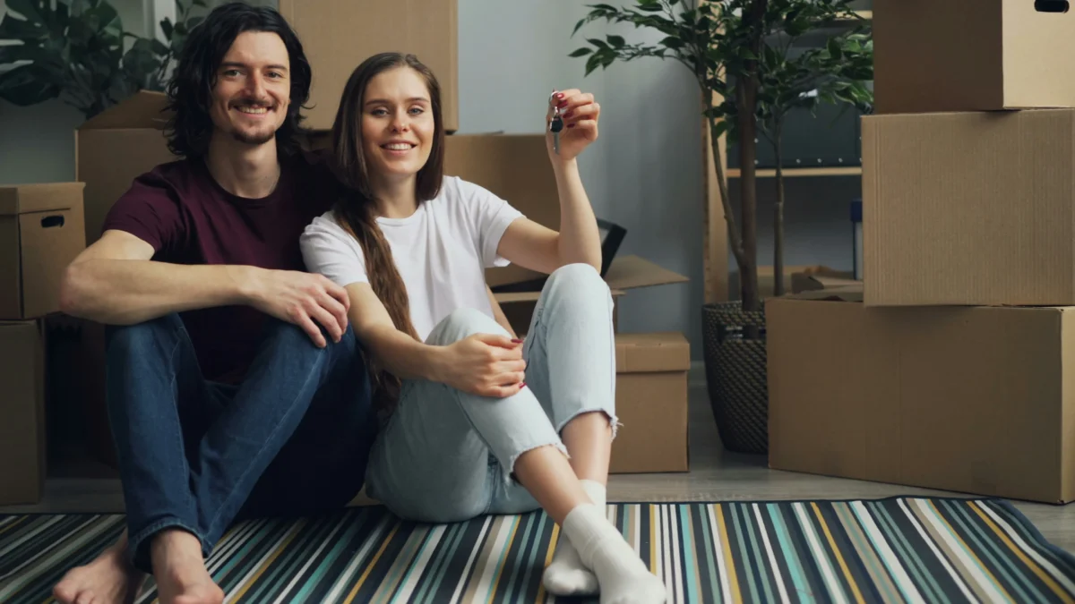 Imagen de una pareja que acaba de firmar su hipoteca y está en su salón con las cajas de mudanza