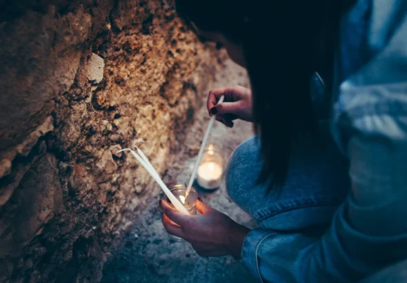Imagen que muestra una chica encendiendo velas en Pedraza para el concierto